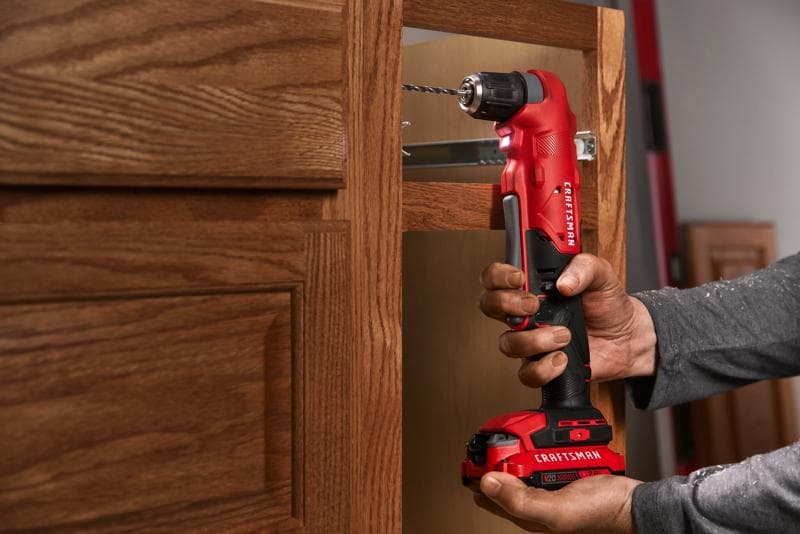 Photo of Craftsman right angle cordless drill CMCD750B in use, drilling inside a wooden cabinet.