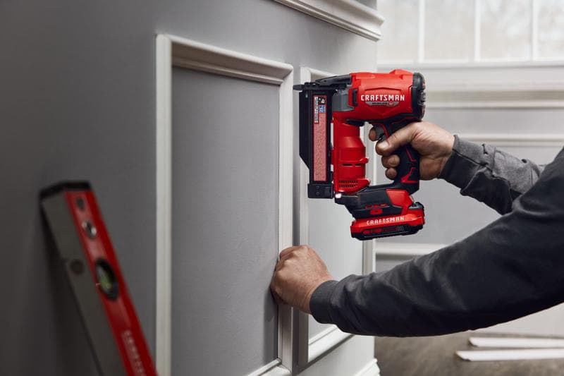 Photo of Craftsman cordless brad nailer CMCN623B in use installing decorative wall trim indoors.