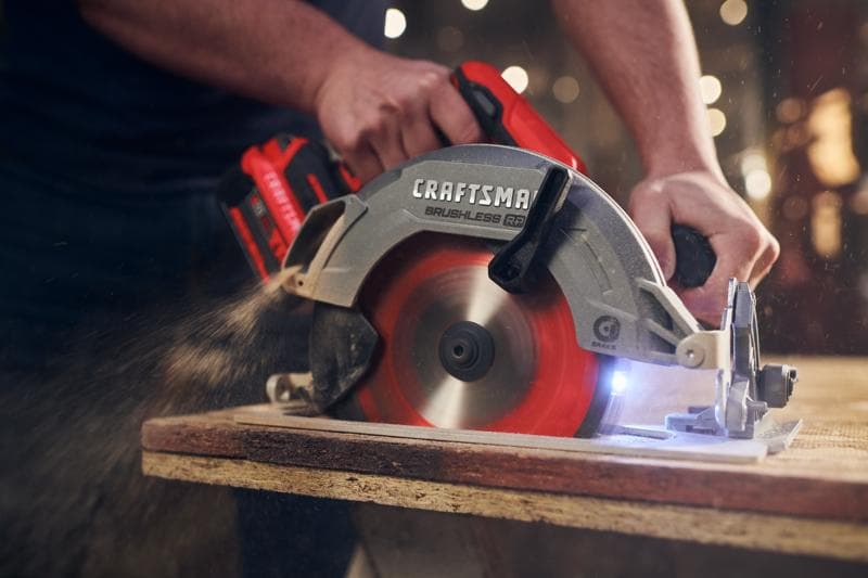 Photo of CRAFTSMAN cordless circular saw CMCS551B in use, cutting wood with visible dust and red blade.