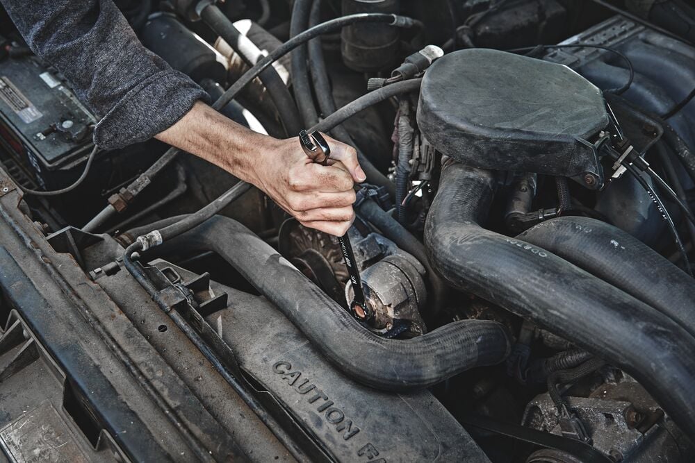 Photo of a hand using Craftsman ratcheting wrench, SKU CMMT87711, on a car engine component.