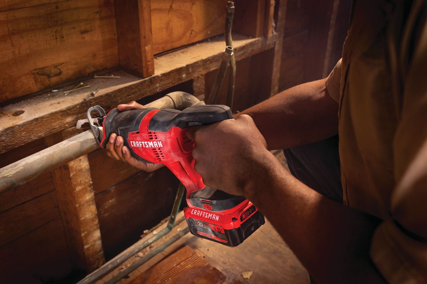 Photo of Craftsman CMCS300M1 cordless reciprocating saw in use, cutting a metal pipe in a workshop setting.