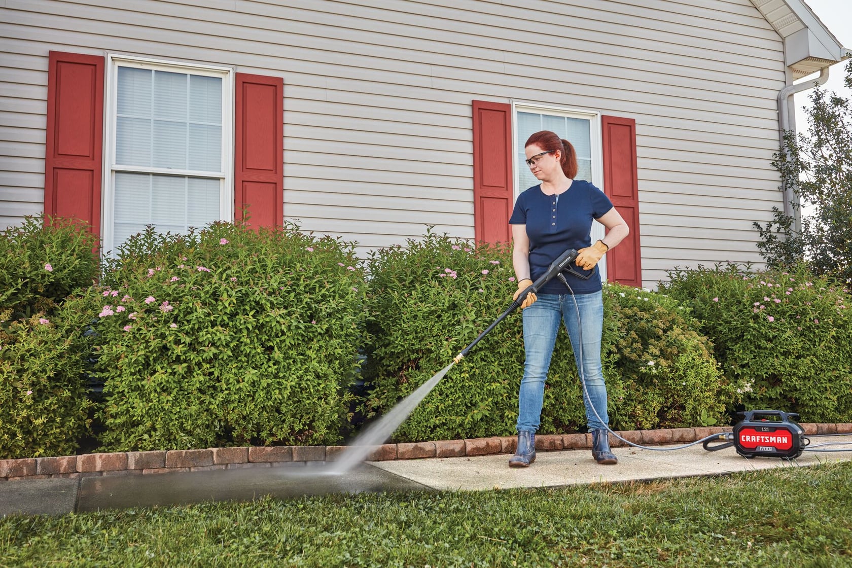 1700 pound per square inch electric compact cold water pressure washer being used by a person.