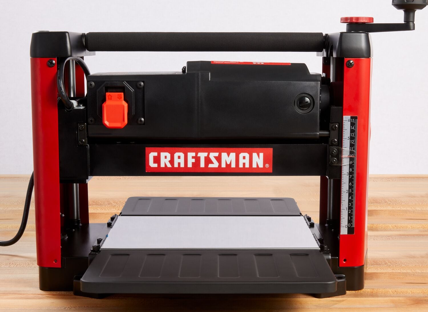 Front view photo of Craftsman benchtop planer CMEW320, black and red with visible depth gauge, on wood surface.