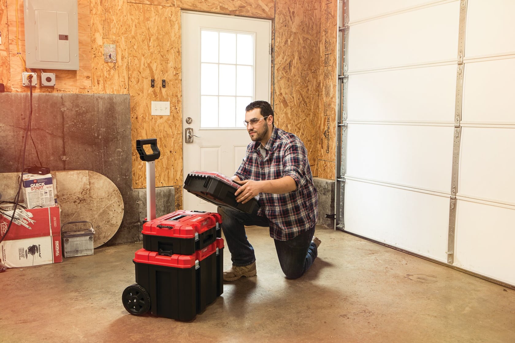 Photo of Craftsman CMST60403 rolling toolbox stack in a garage, person placing a case on the stack, product in use.