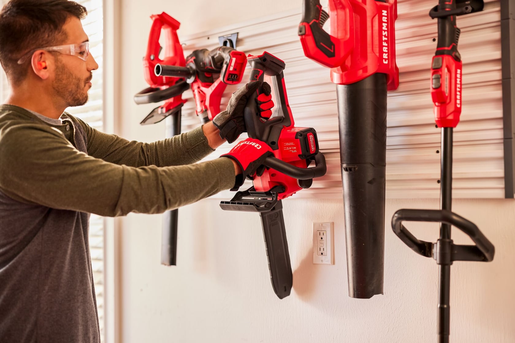 Side angle of male hanging V20 Chainsaw on Versatrack 