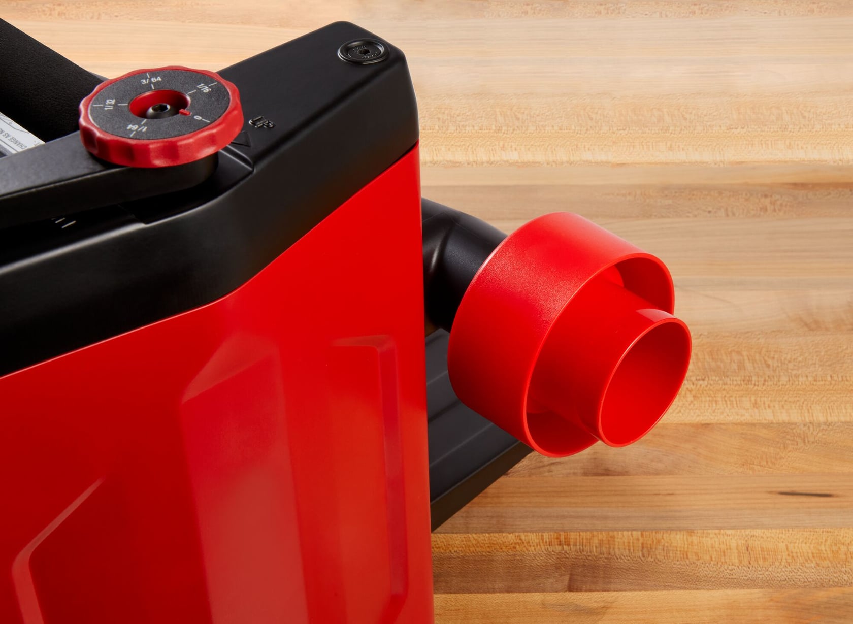 Photo of Craftsman CMEW320 benchtop jointer dust port and adjustment knob, red and black finish, angled view.