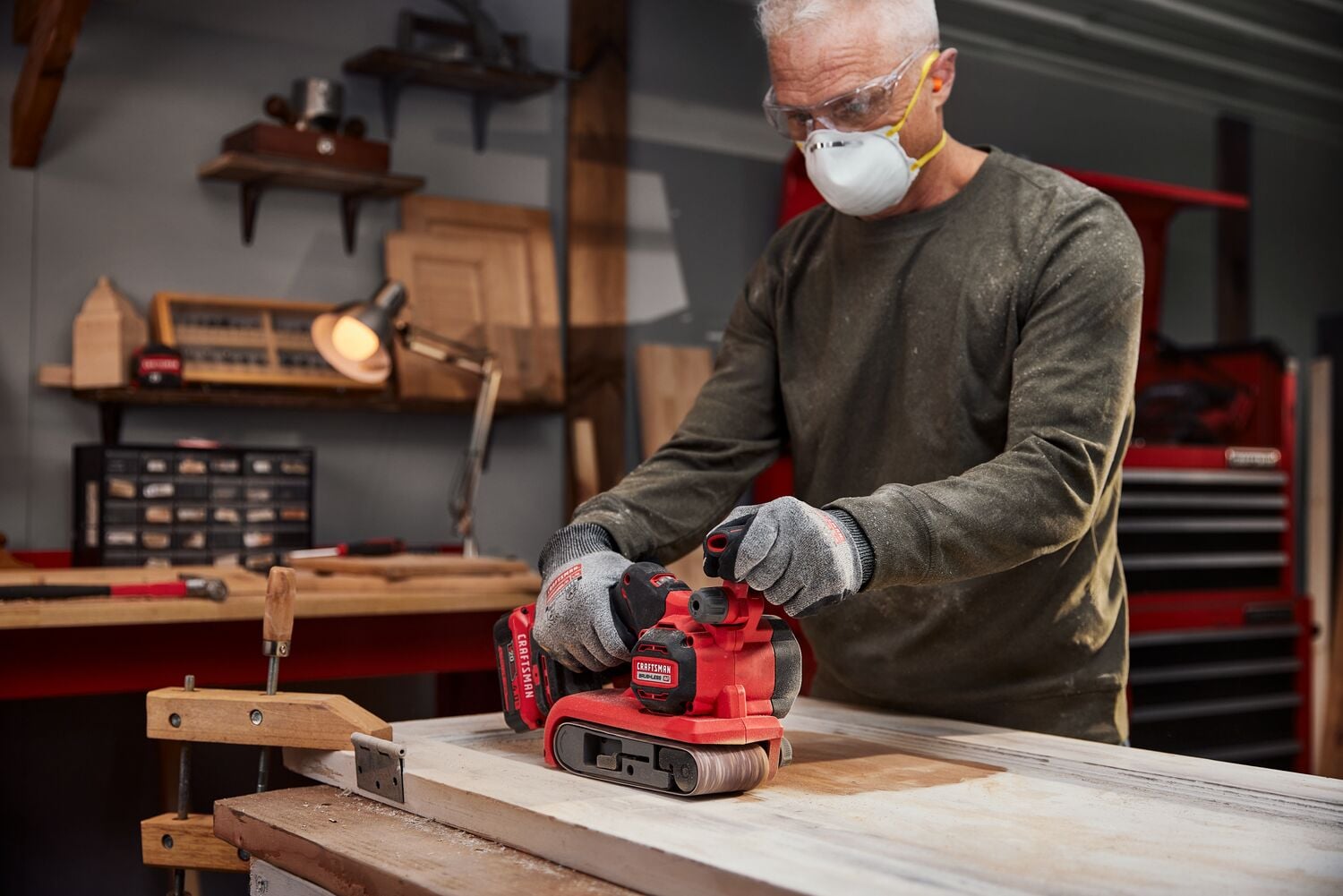 Man using Craftsman Brushless RP Belt Sander on a wood door