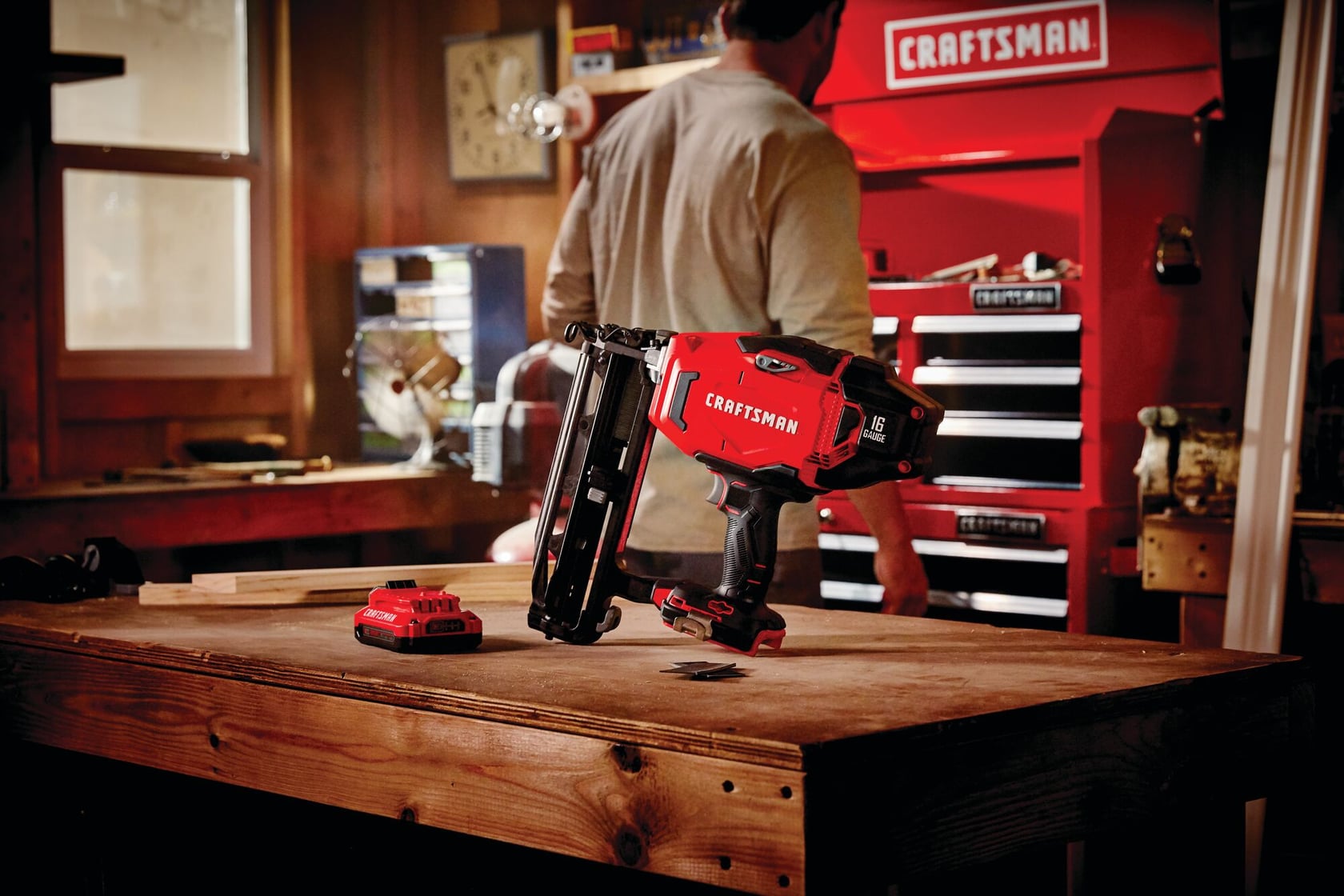 20 volt cordless 16 gauge finish nailer kit placed on a wooden table at a work station.