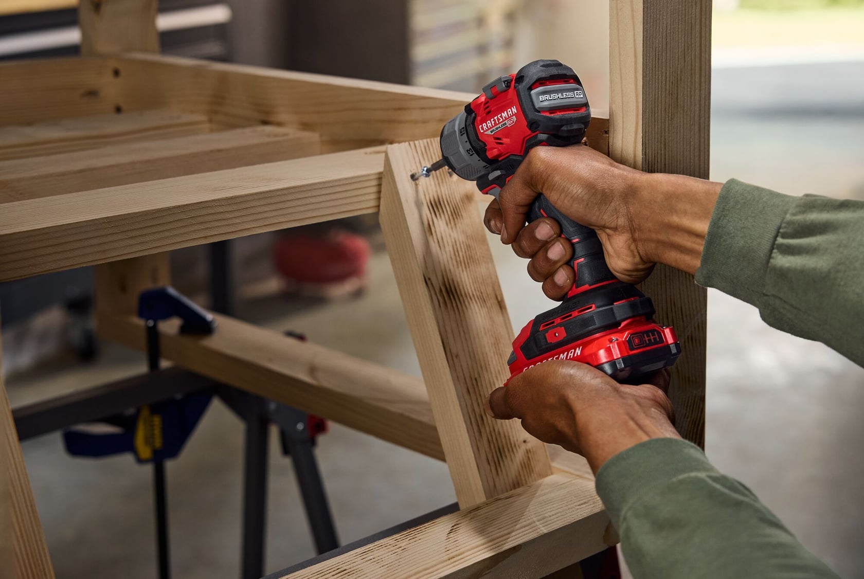 Photo of Craftsman CMCF610B cordless impact driver drilling into wood frame, close-up view.