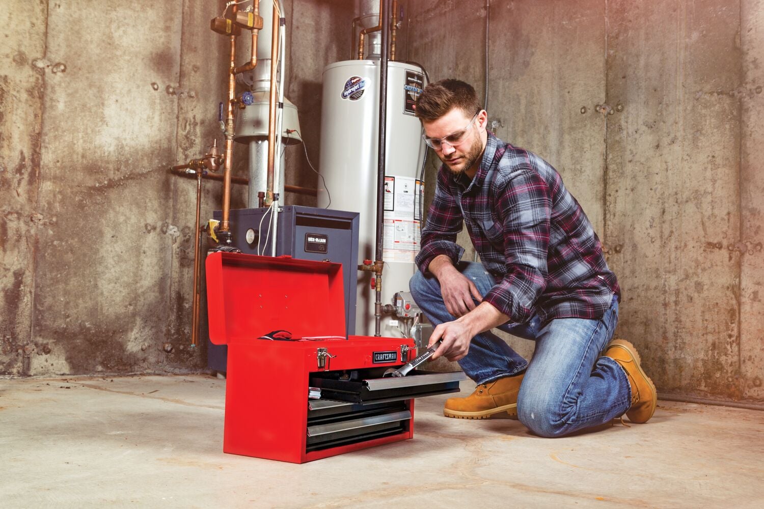 Portable 20 and 5 tenths inch Ball bearing 3 Drawer Red Steel Lockable Tool Box being used by person to store a spanner in drawer.