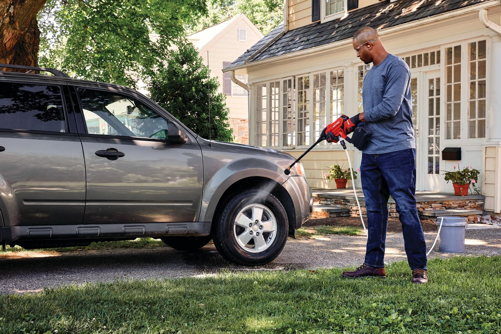 20 volt cordless 350 max P S I power cleaner being used by a person to clean car tyre outdoors.