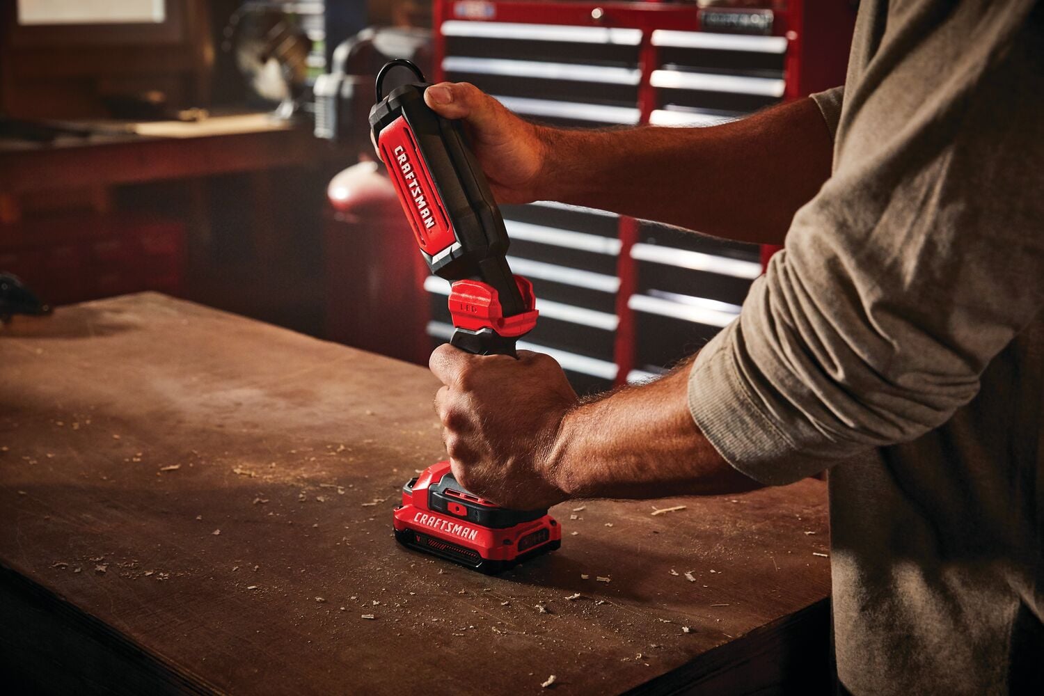 Cordless led hanging work light tool only being held by person.