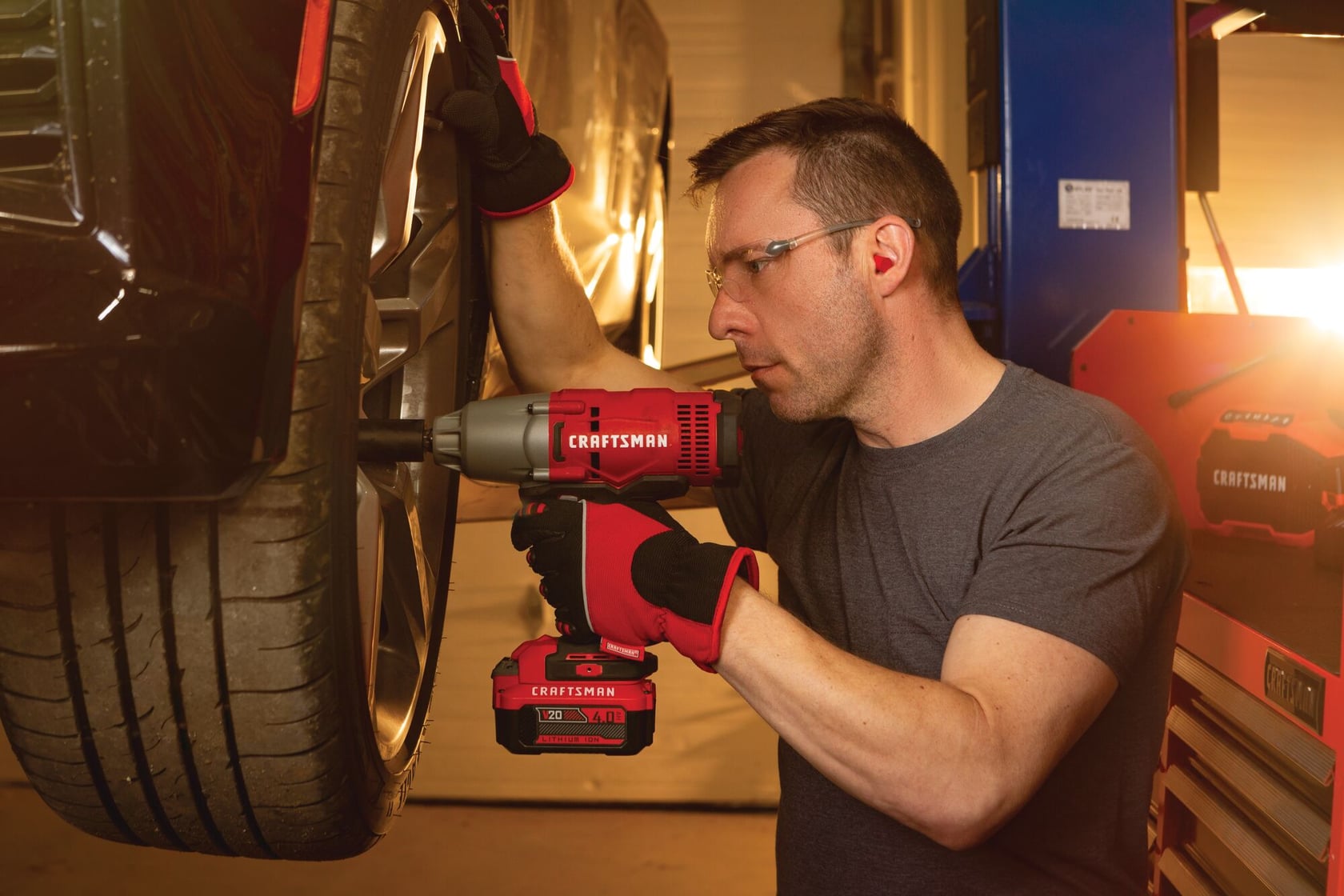 Cordless half inch impact wrench kit 1 battery being used to tighten tyre screws by person.
