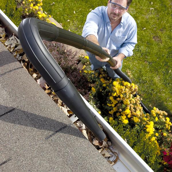 Rooftop view of man blowing debris from gutter using the CRAFTSMAN Wet/Dry Vac Gutter Cleaning Kit