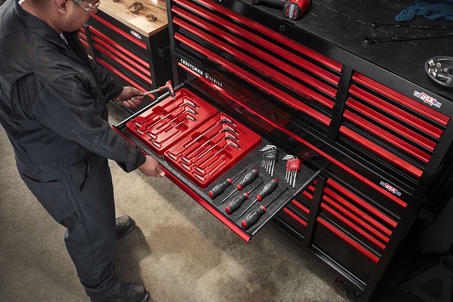 Mechanic working in automotive shop filled with various CRAFTSMAN V-Series™ storage and tools