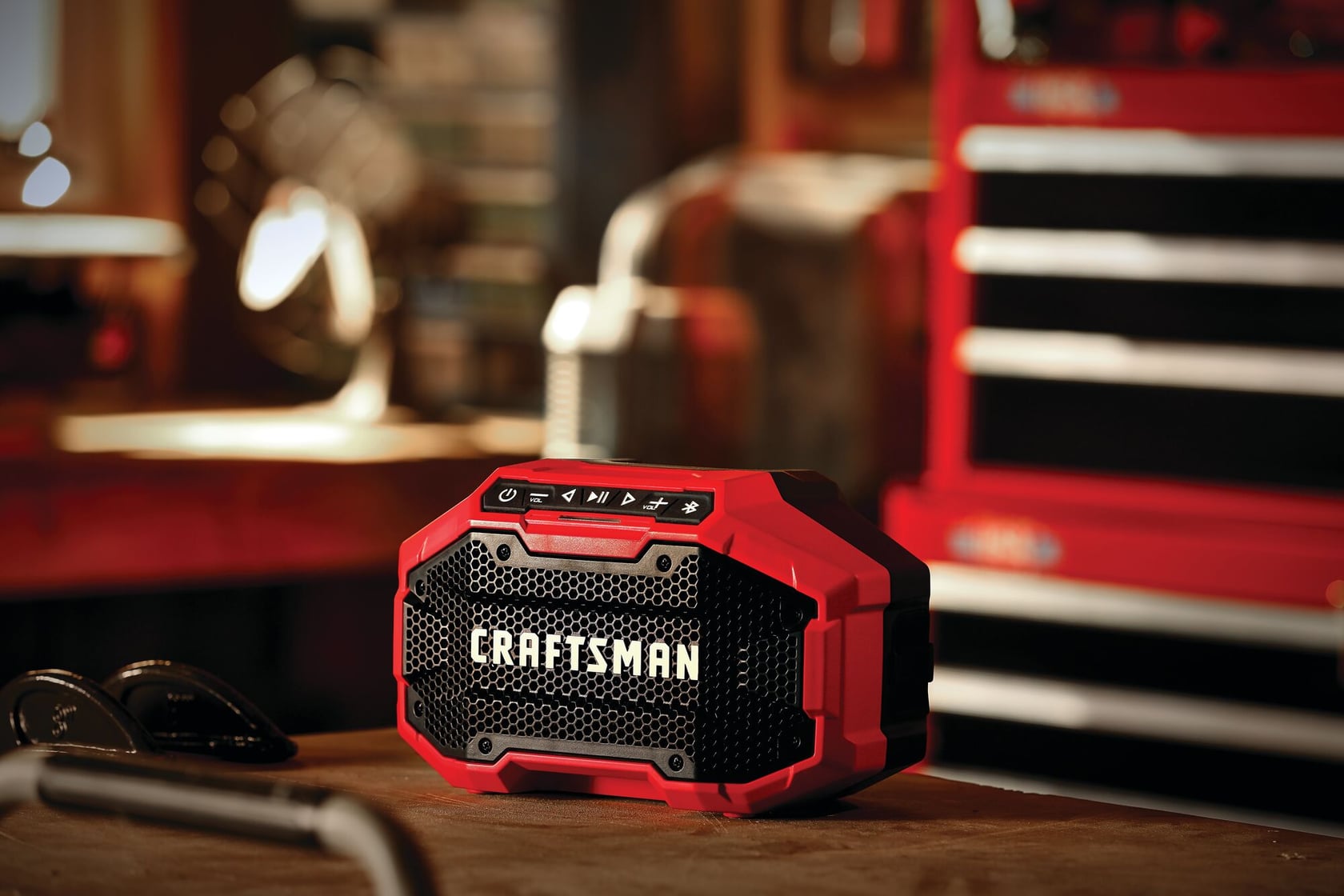 20 volt cordless bluetooth speaker placed on a wooden work station in a work shop.