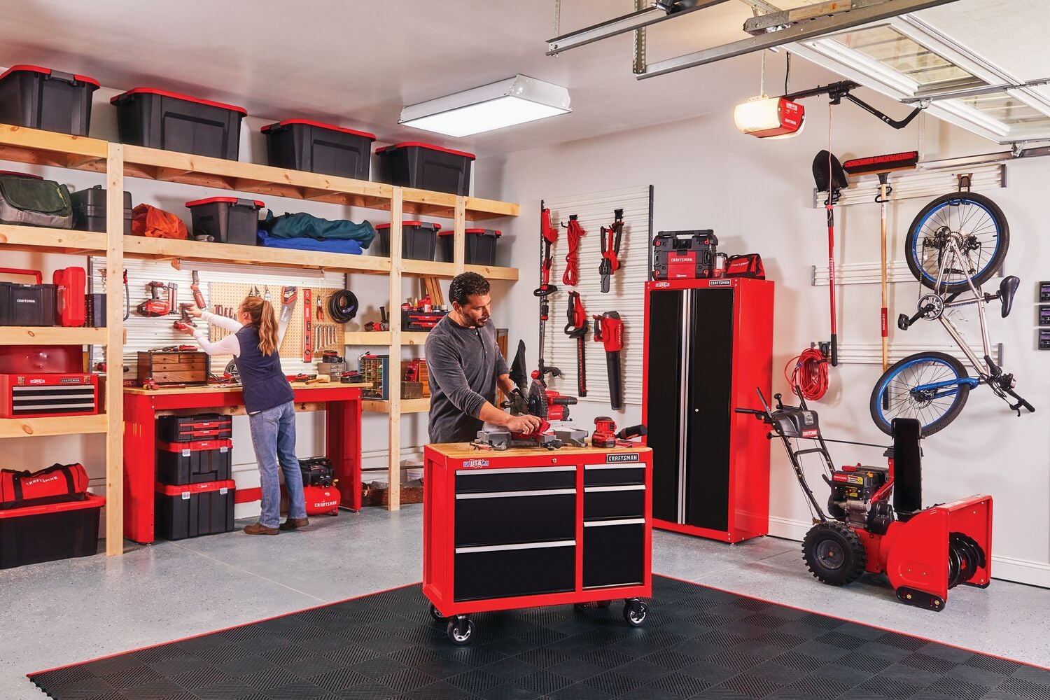 Person hanging tools on Versa Track 5 and 5 tenths inch White Composite Multipurpose Storage Rail System installed inside wooden tool storage rack in a home workshop.