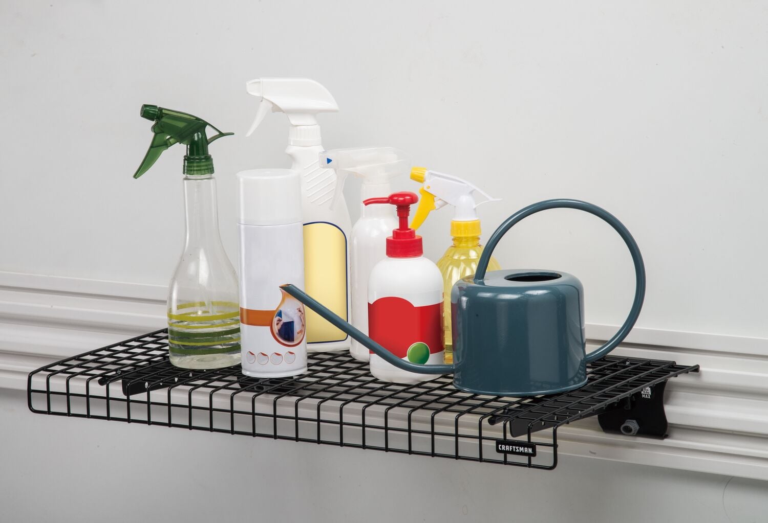 Black VERSATRACK Wire Shelf attached to white VERSATRACK trackwall with assorted bottles resting on it
