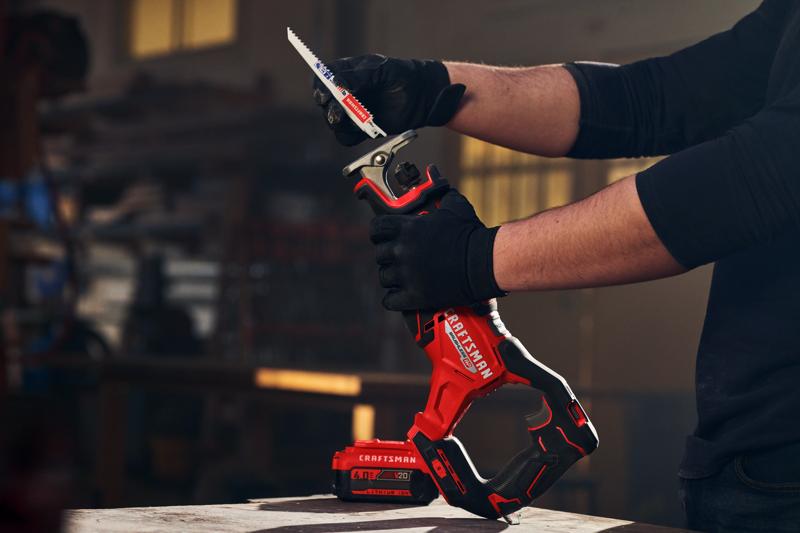 Photo of Craftsman reciprocating saw CMCS351B with battery, held by gloved hands in workshop setting.