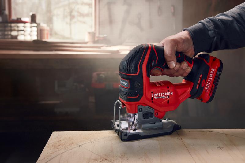 Photo of a Craftsman cordless jigsaw, SKU CMCS650B, in use cutting wood in a workshop setting.