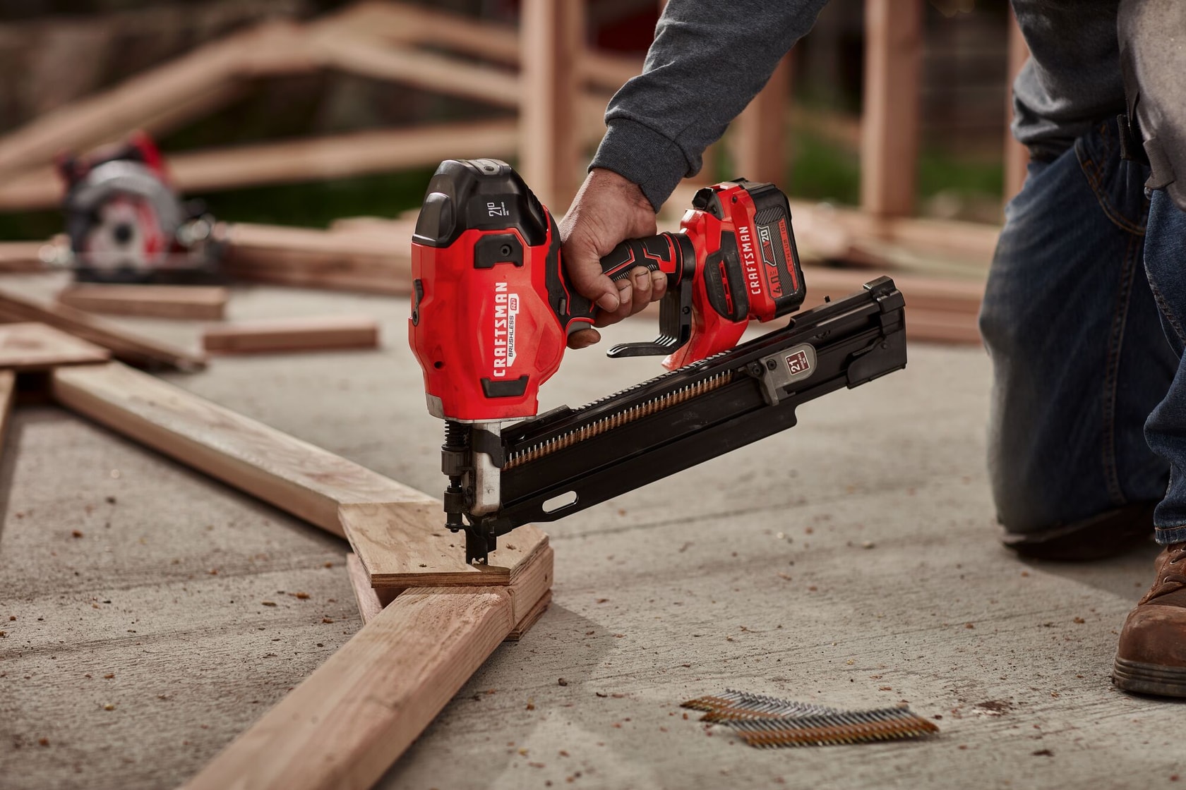 20 volt brushless cordless 21 degree plastic collated framing nailer being used by a person on wooden frame.