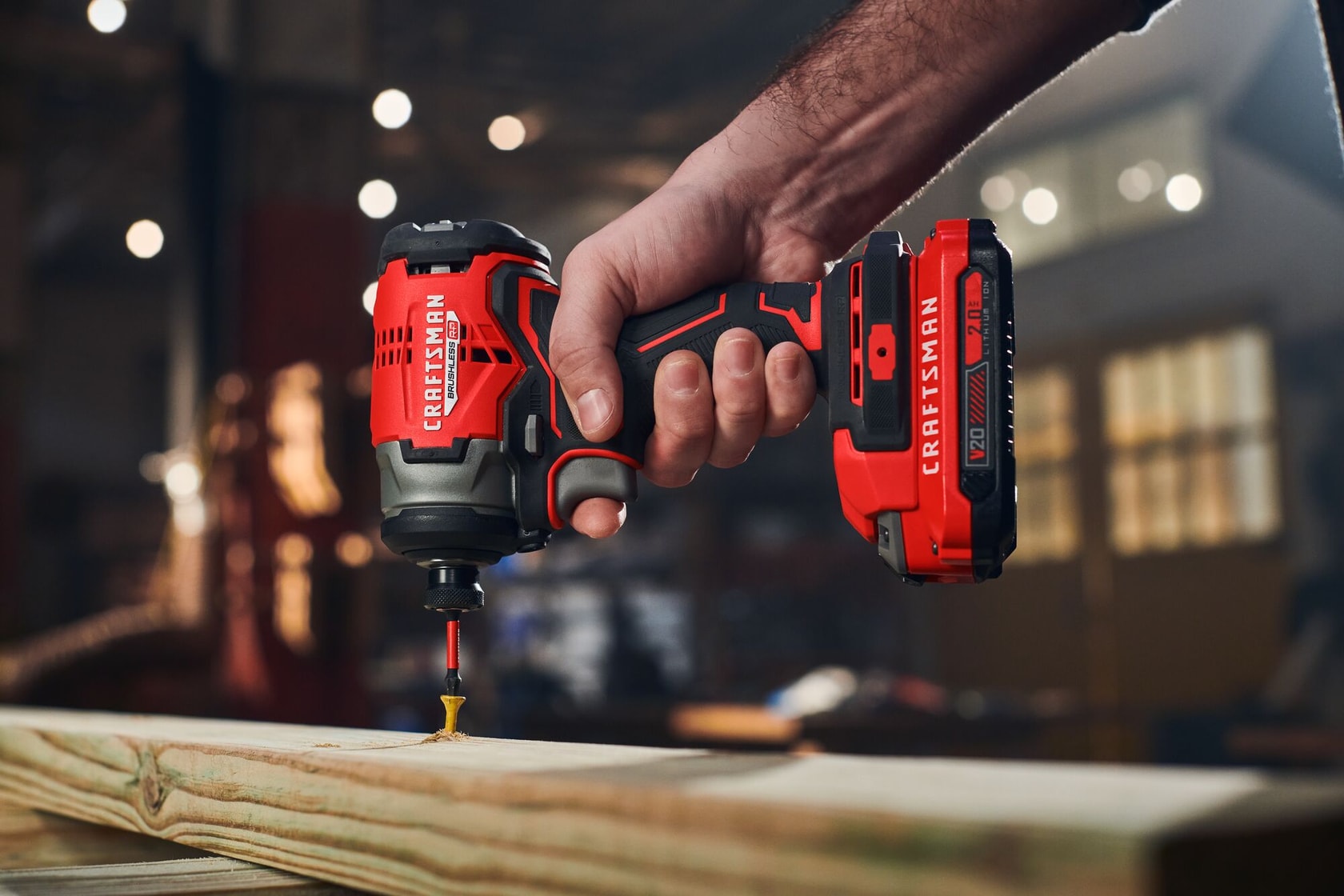 Man in dark shirt drills into wood with CRAFTSMAN V20 drill.