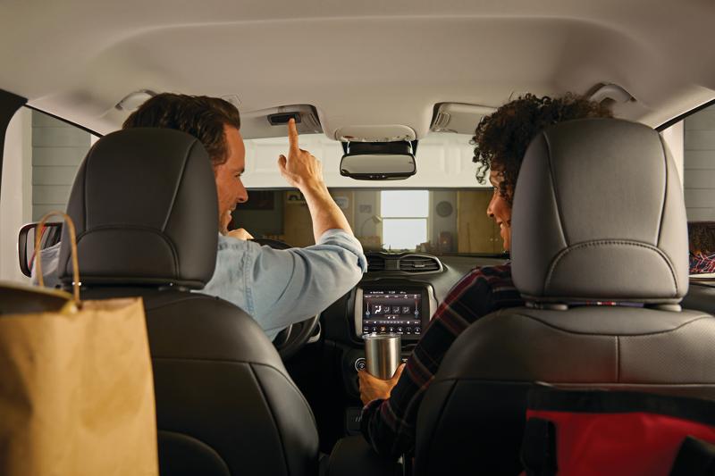 3 Button remote control being used by a person to open garage.
