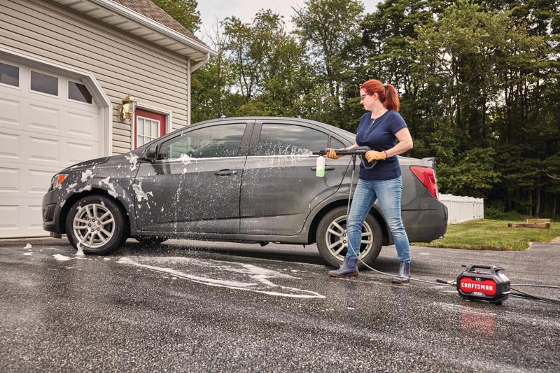 1700 pound per square inch electric compact cold water pressure washer being used by a person.