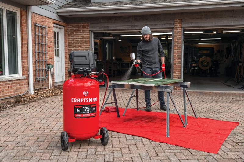 33 gallons 175 p s i oil free portable vertical air compressor being used for spray painting.