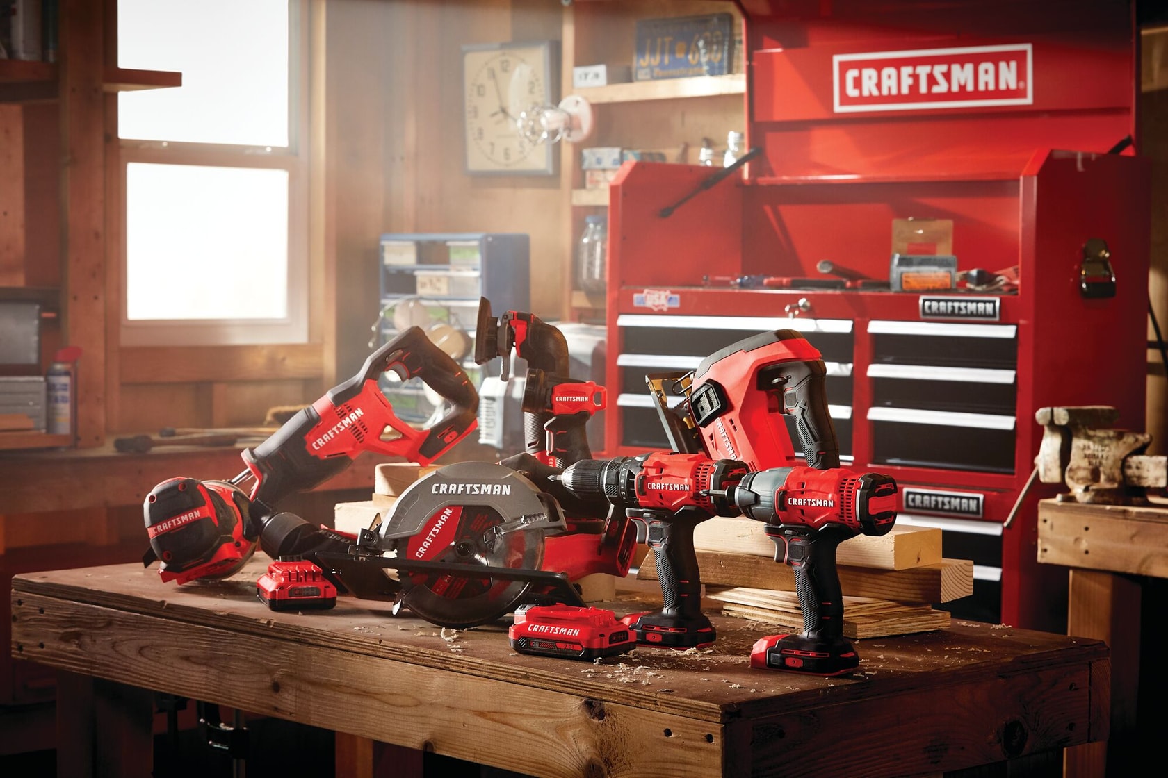 Cordless 8 tool combo kit 2 batteries placed on wooden table in workshop.