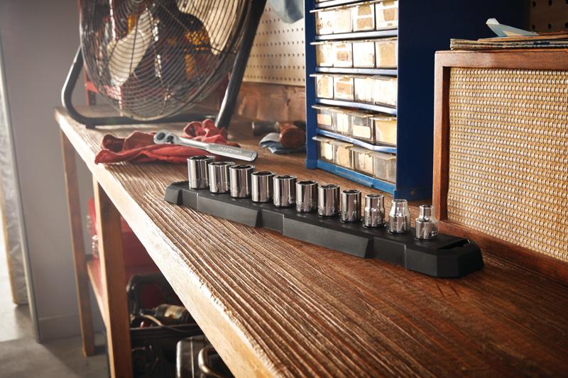 11 piece 3 eighths inch drive s a e 6 point socket set placed on wooden table in workshop.