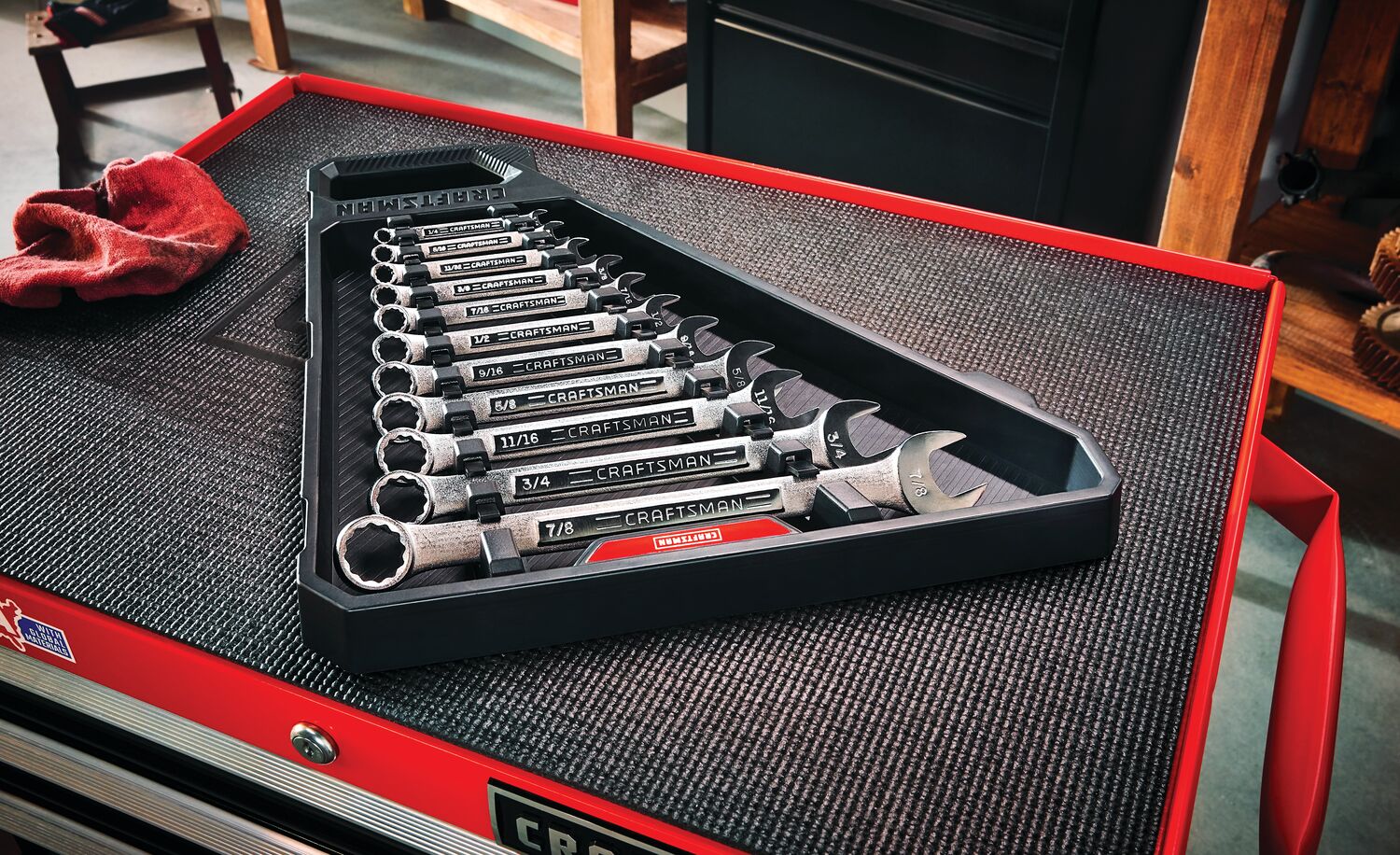 11 piece S A E raised panel combination wrench set on a work table.