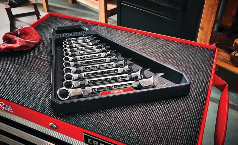 11 piece S A E raised panel combination wrench set on a work table.
