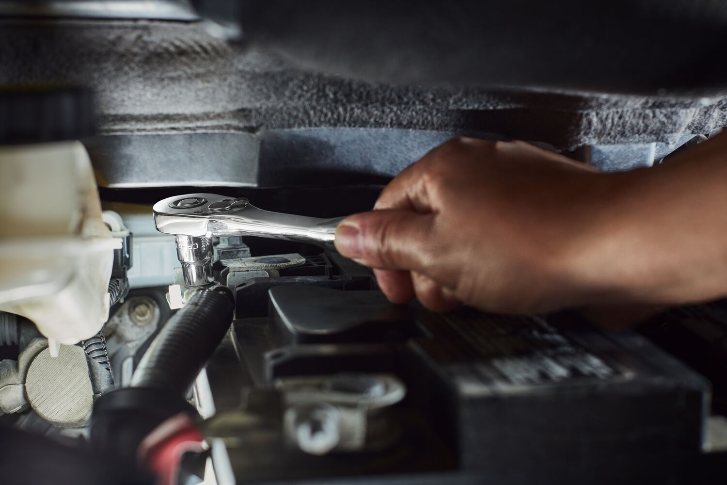 User changing the spark plug on a lawnmower using the CRAFTSMAN 3/8" drive ratchet