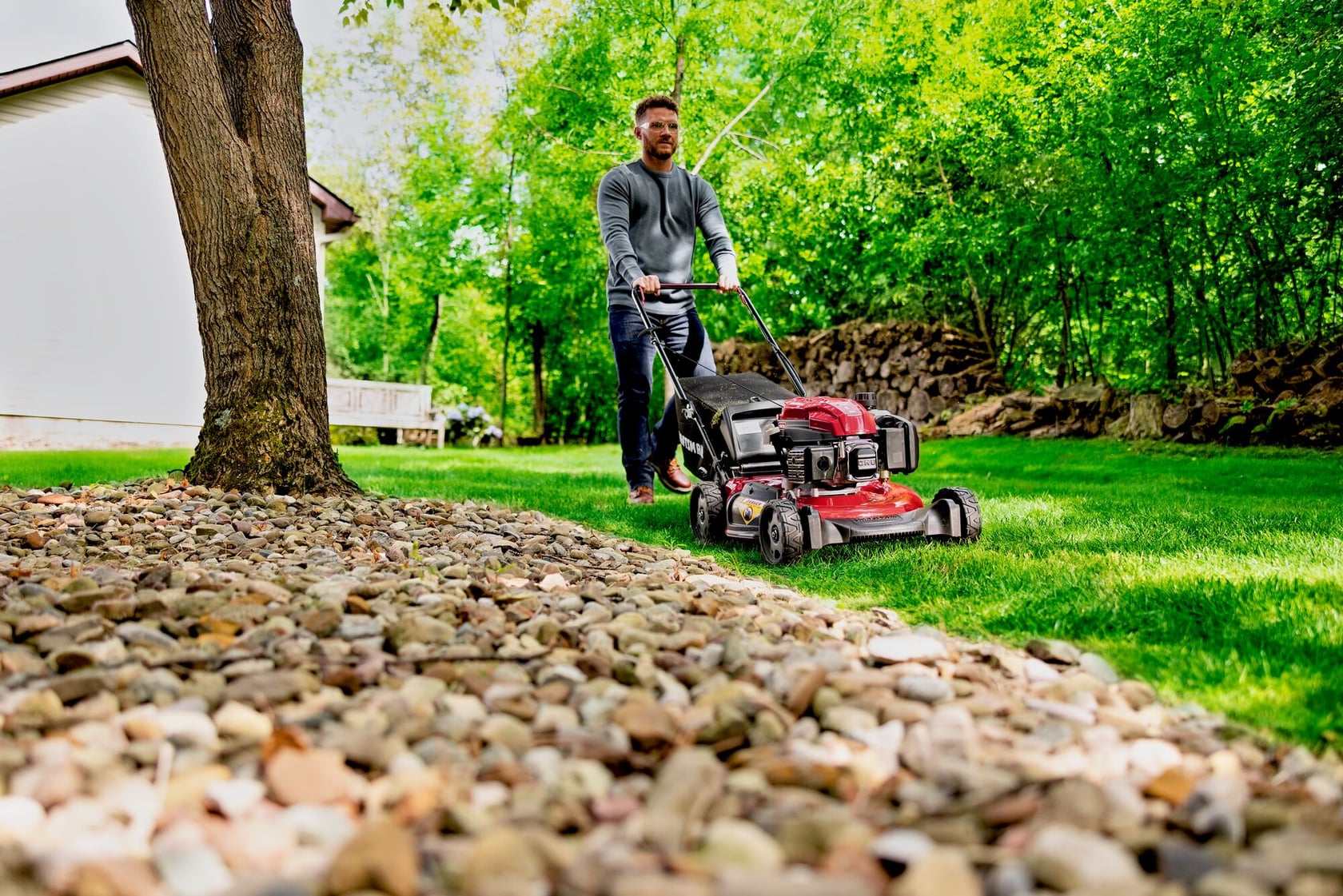Man cutting grass with CRAFTSMAN M110C Gas Walkbehind Mower
