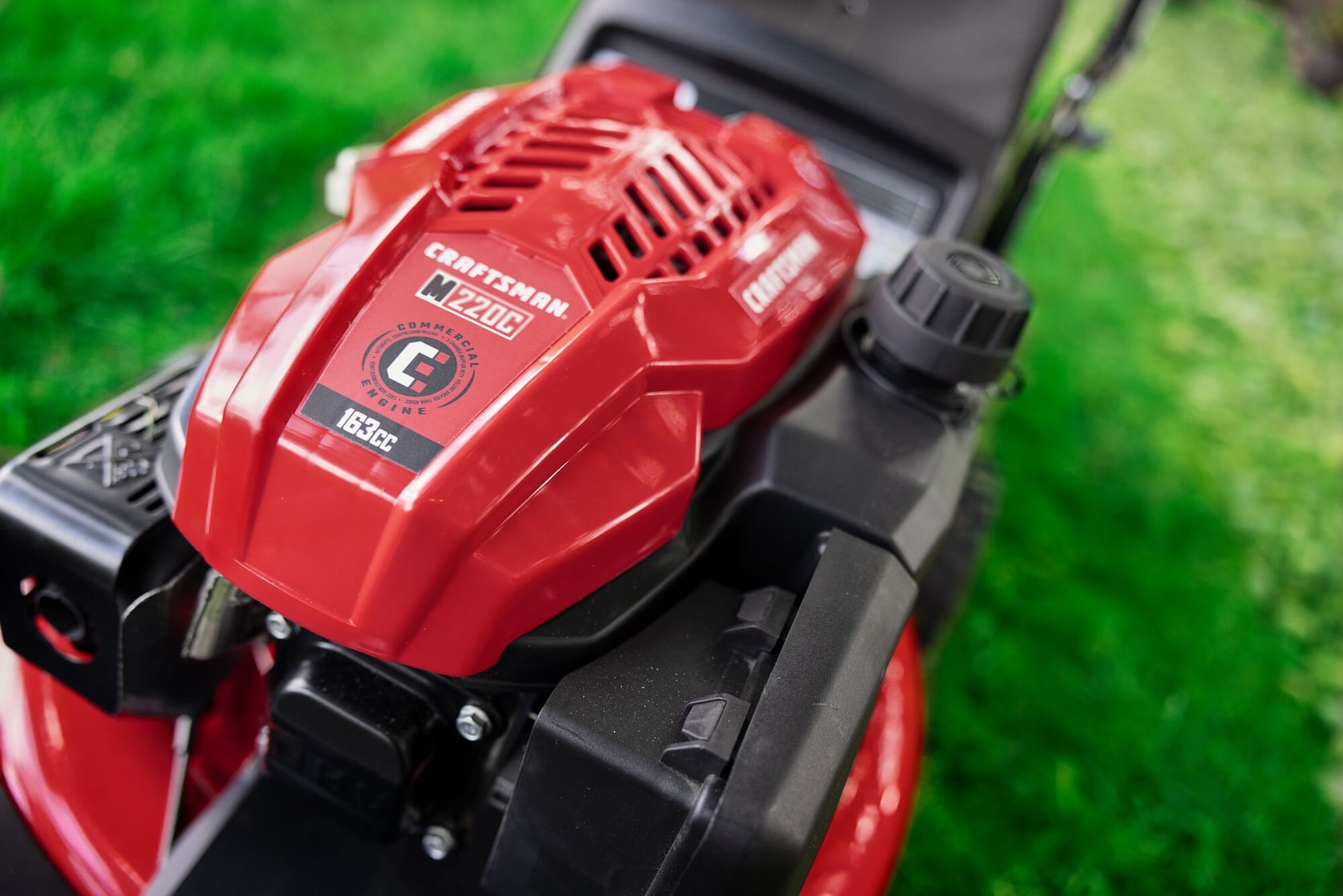 Photo of Craftsman lawn mower engine CM12A-A2C2093, red housing, close-up, on grass.