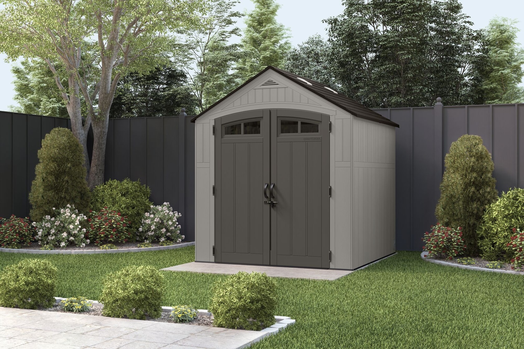 Photo of Craftsman outdoor storage shed CMXRSSC7750 with gray double doors, shown in a landscaped backyard.
