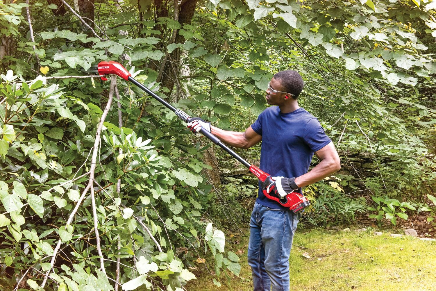 Cordless pole chainsaw kit 4 amp hour being used for cutting tree branches.