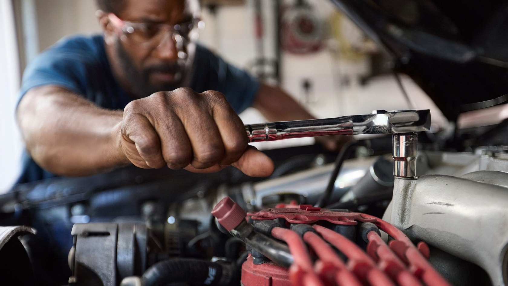 Man using OVERDRIVE ratchet to tighten bolts on a car
