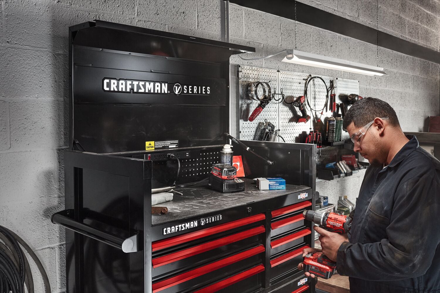 Mechanic working in automotive shop filled with various CRAFTSMAN V-Series™ storage and tools