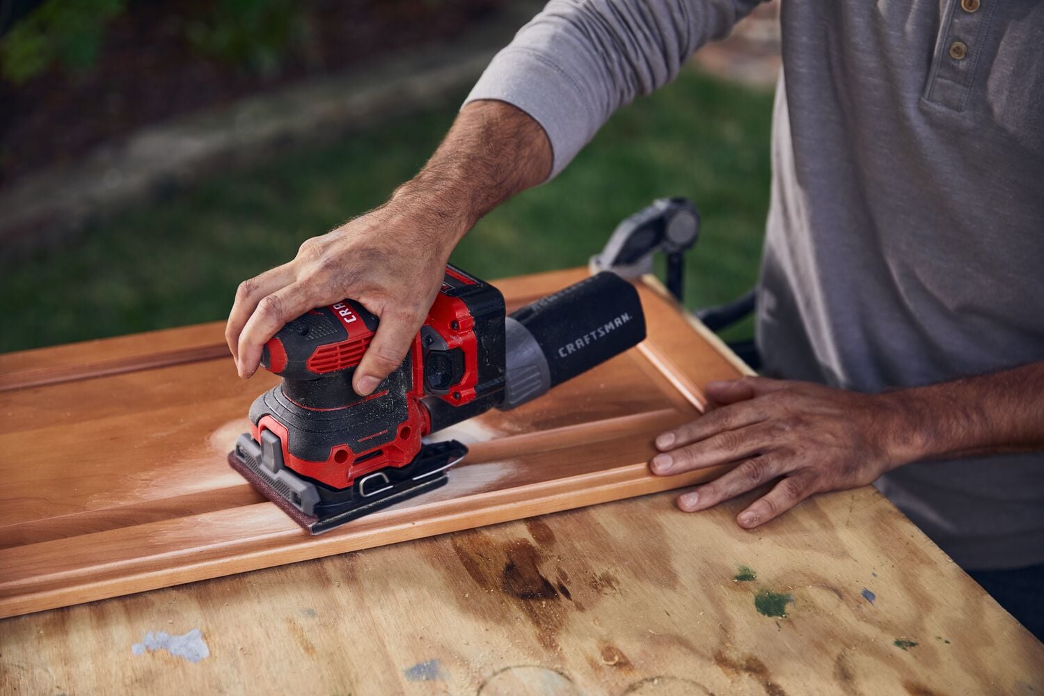 20 volt cordless quarter sheet sander in use.