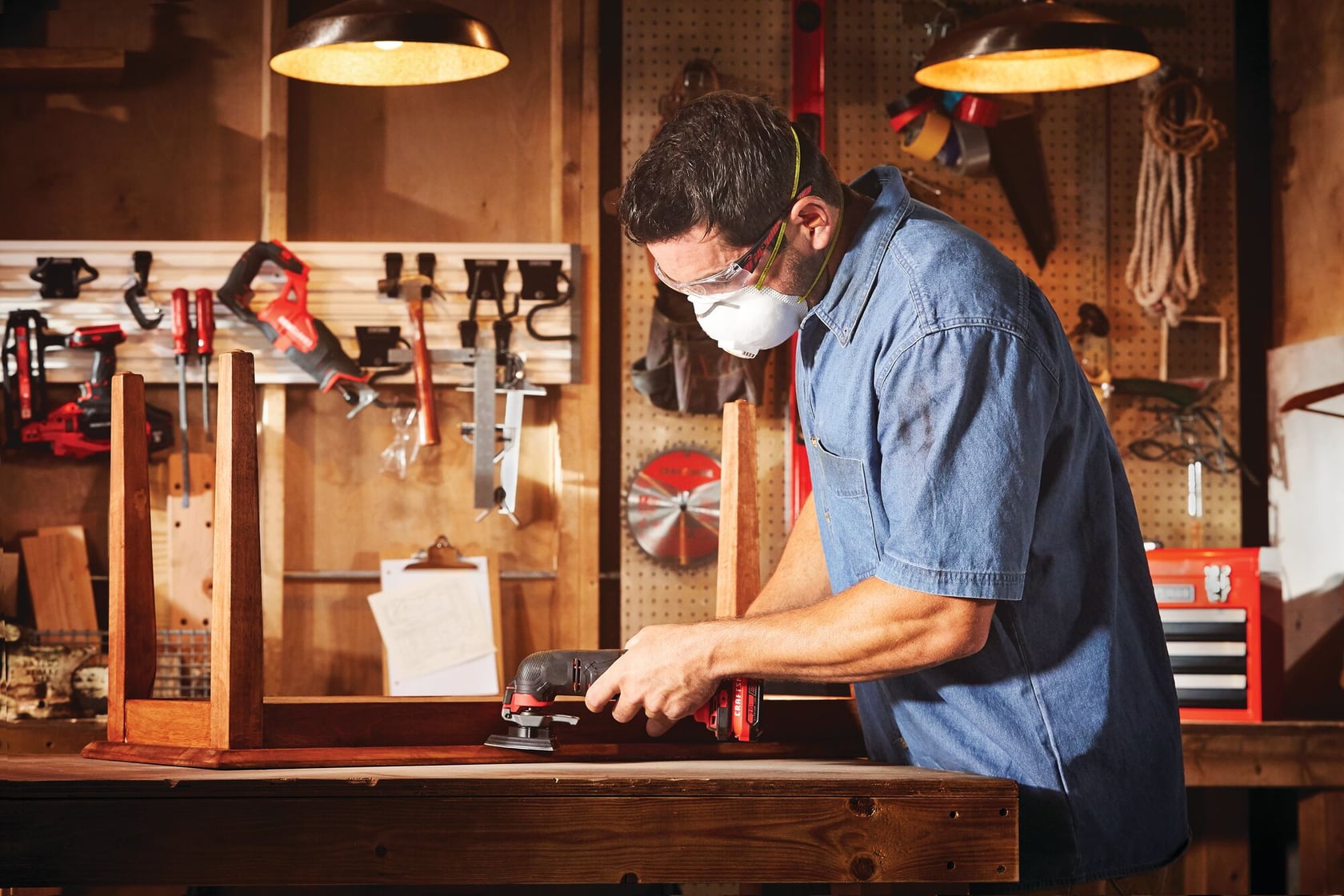 Cordless oscillating tool kit being used on wooden table.
