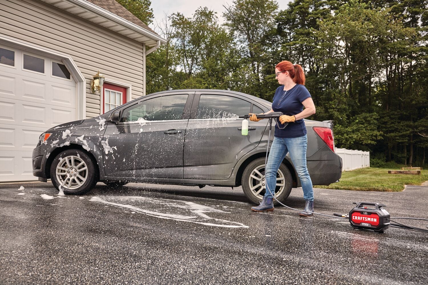 Photo of Craftsman CMEPW1700 pressure washer cleaning a car in a driveway, person holding spray wand.