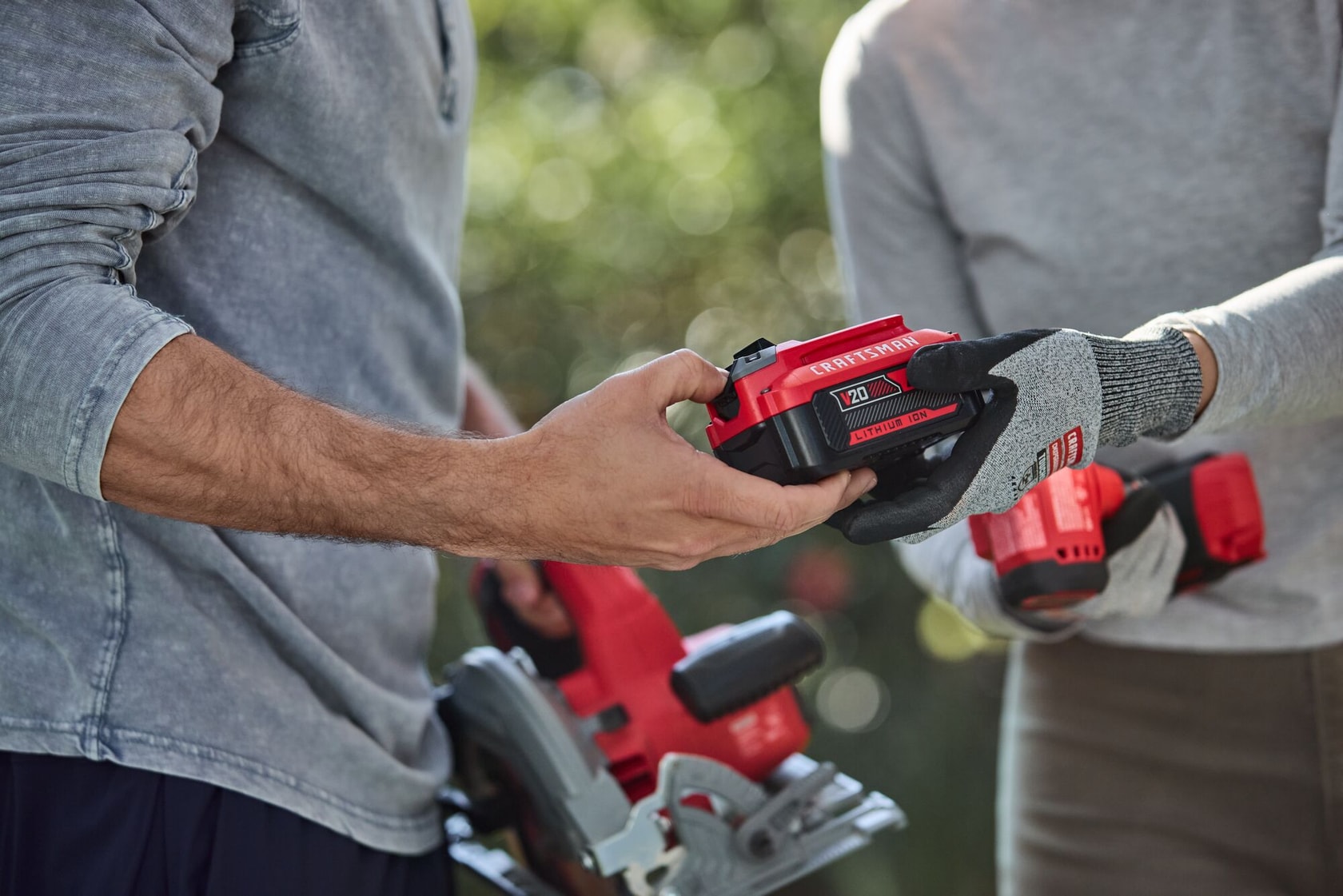 Man handing woman CRAFTSMAN V20* 4 AH battery