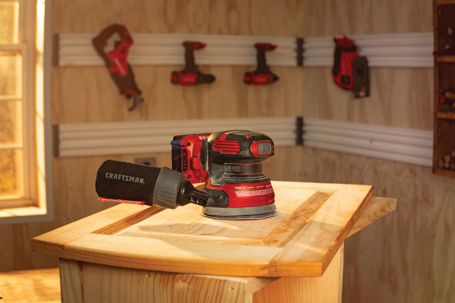 20 volt cordless random orbit sander lying on a work table.