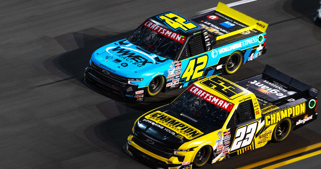 Two NASCAR race trucks on a track with CRAFTSMAN®-branded truck wraps